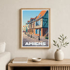 Poster d'art d'Amiens sous cadre posé sur une console moderne en bois clair dans une entrée