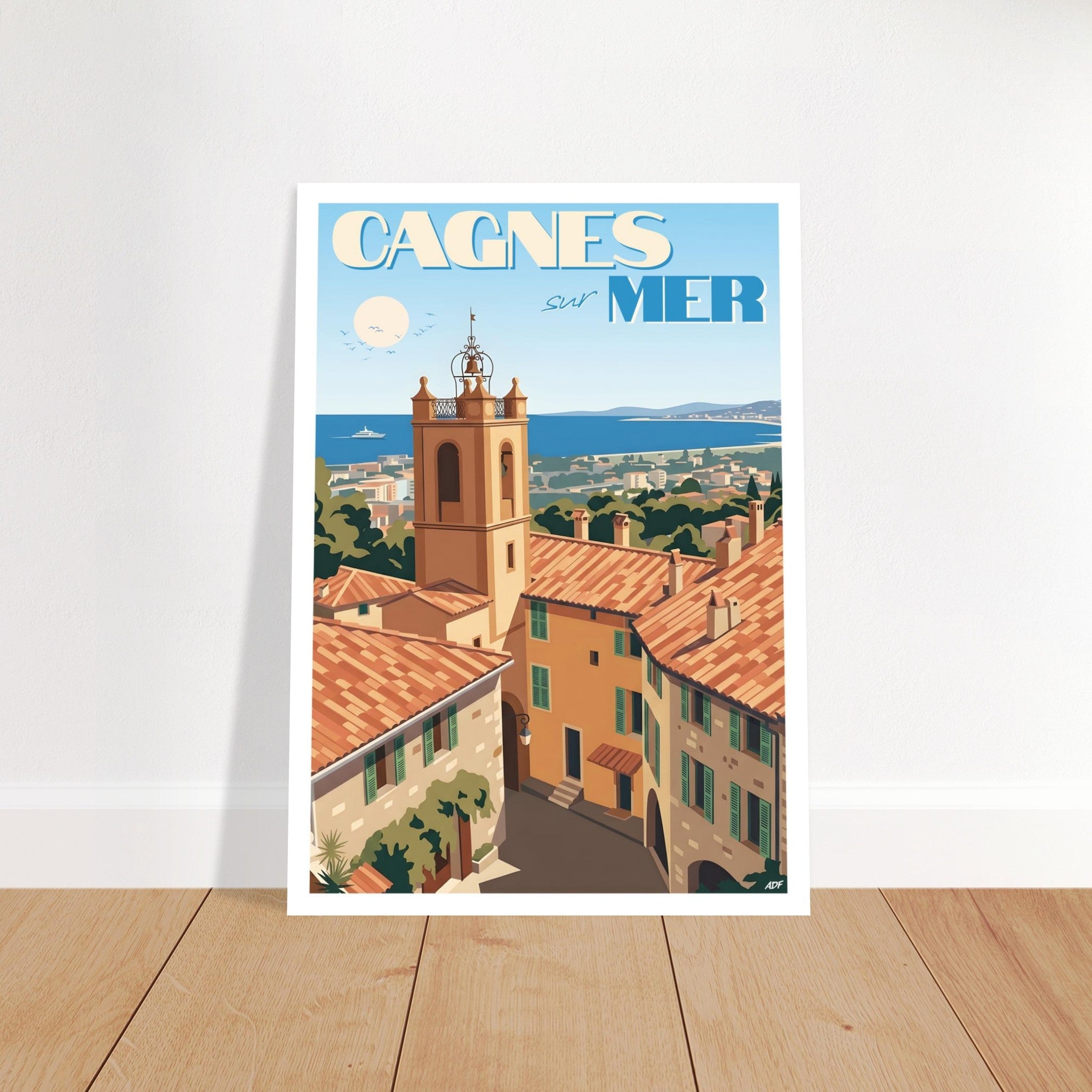 Affiche d'art de Cagnes-sur-Mer encadrée et posée sur parquet dans un intérieur chaleureux