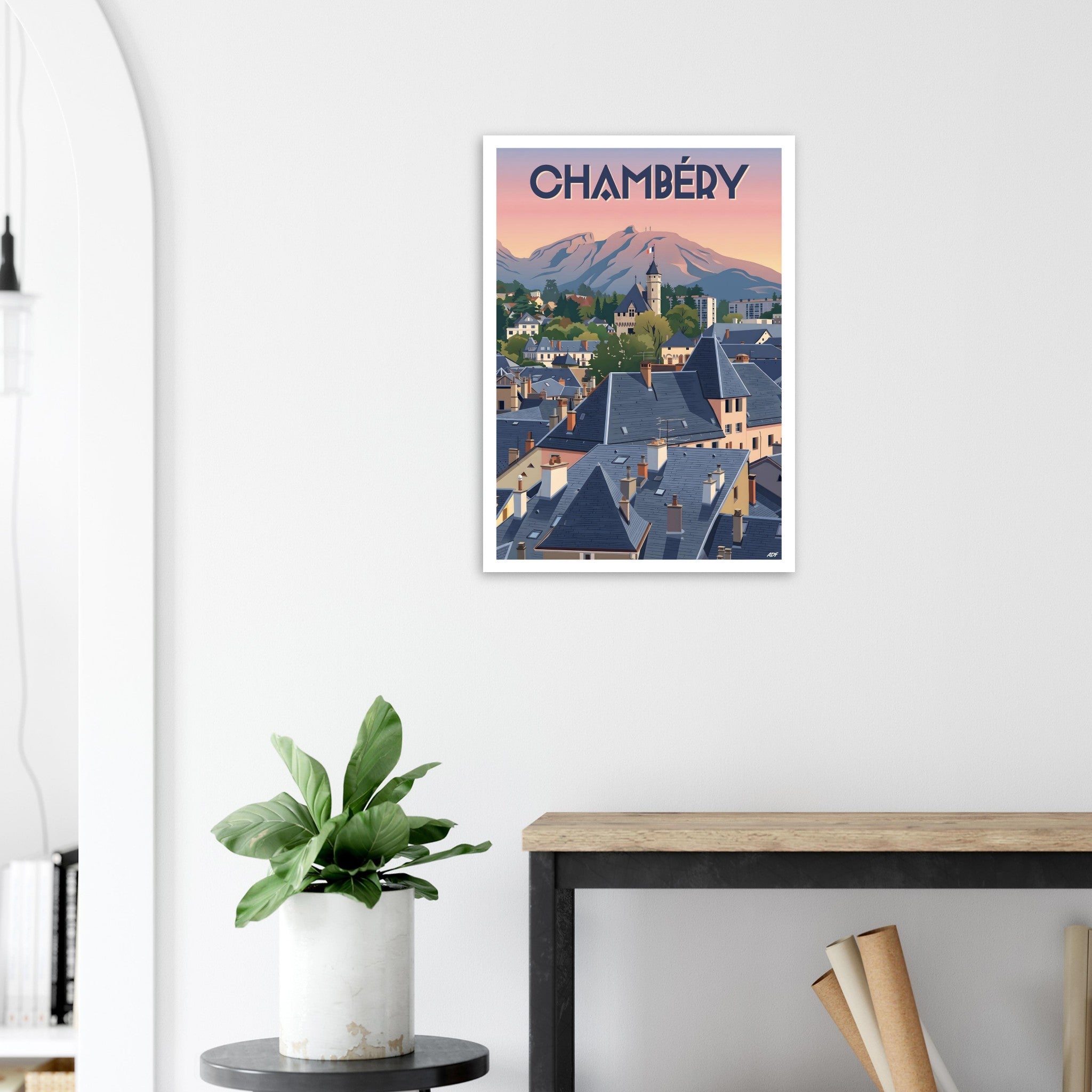 Poster de voyage de Chambéry sous cadre posé sur une console en bois clair dans une entrée