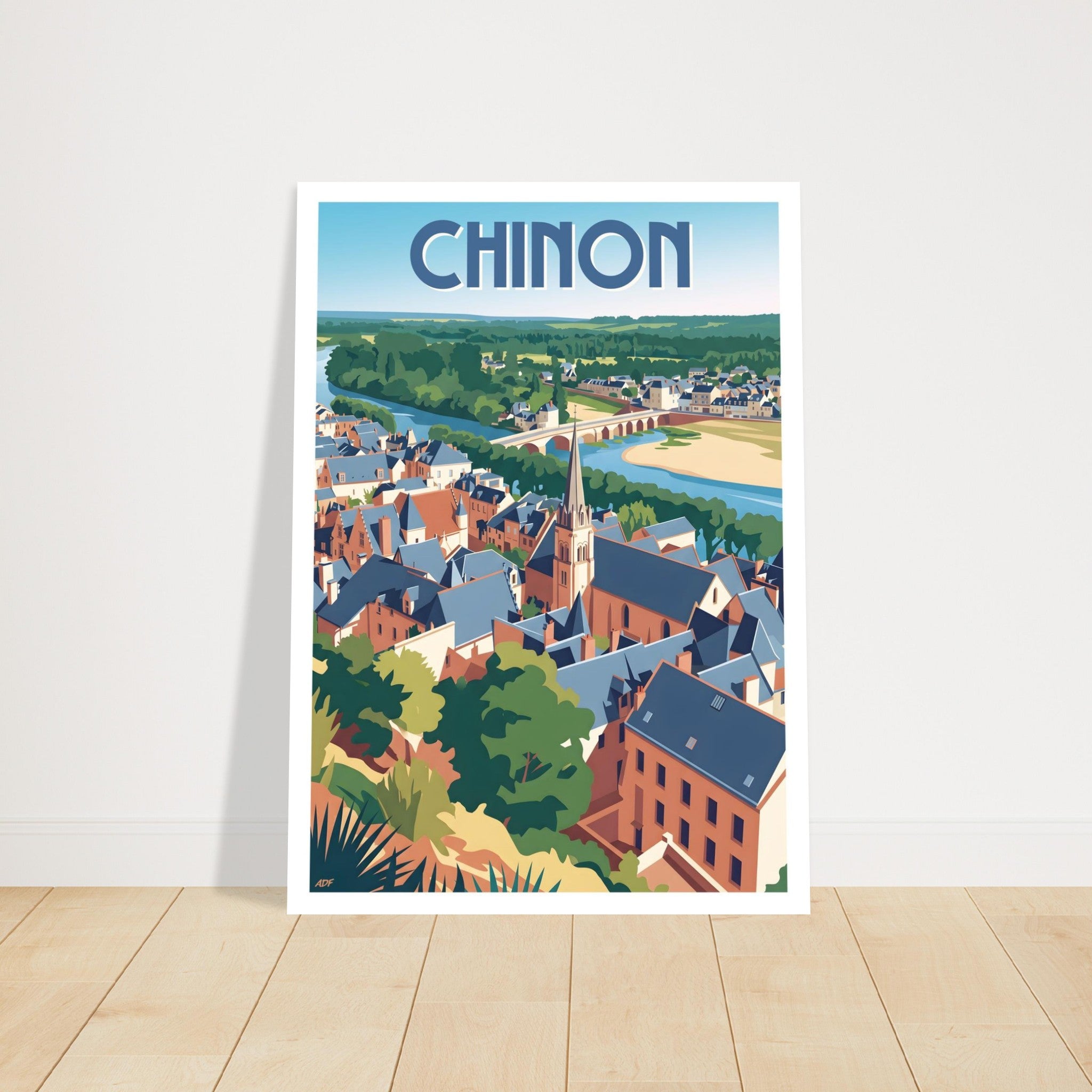 Grand cadre mural avec le poster de Chinon posé au sol sur parquet en bois