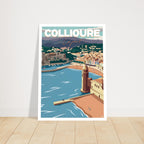 Grand poster encadré de Collioure posé sur parquet en bois contre un mur blanc
