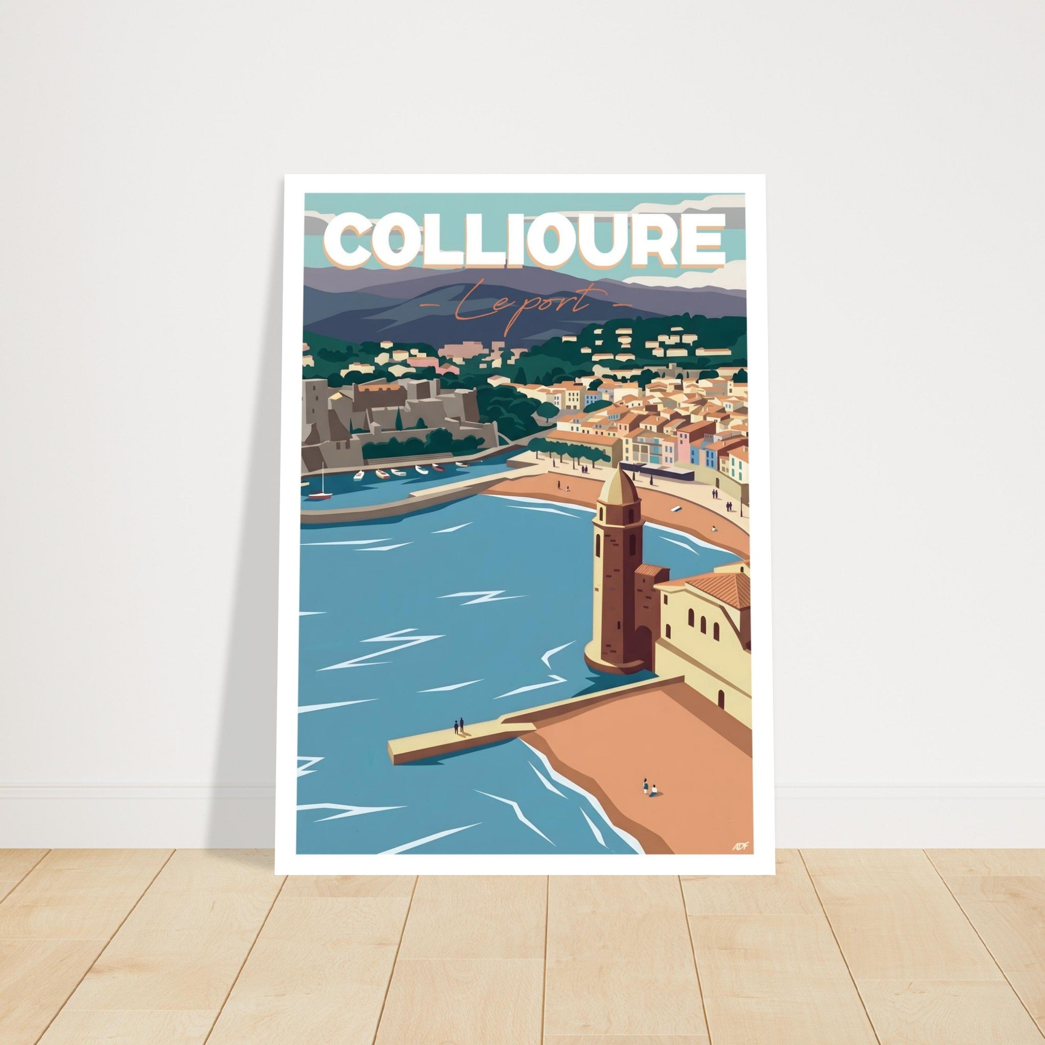 Grand poster encadré de Collioure posé sur parquet en bois contre un mur blanc