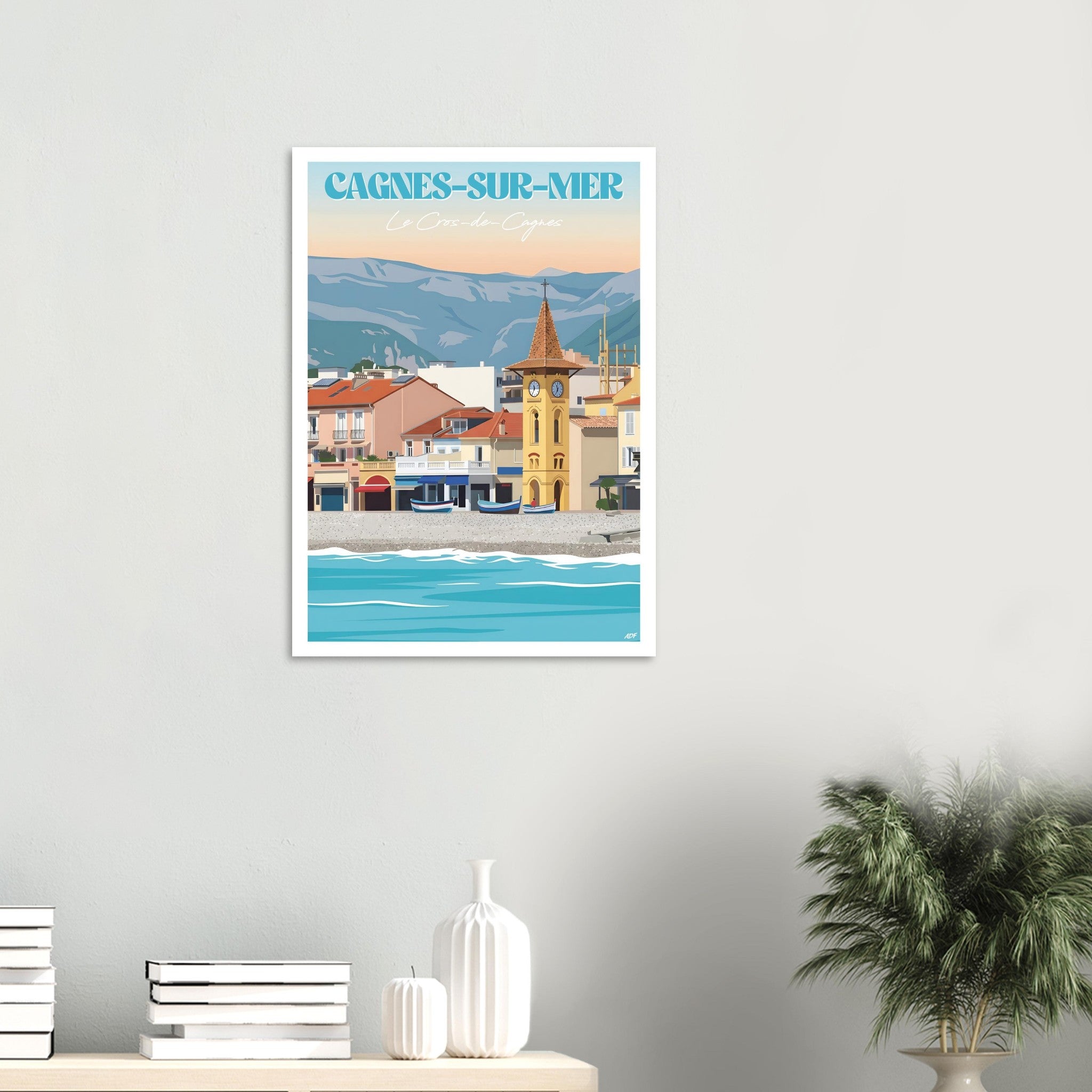 Grand poster encadré du Cros-de-Cagnes posé sur un sol en parquet contre un mur blanc