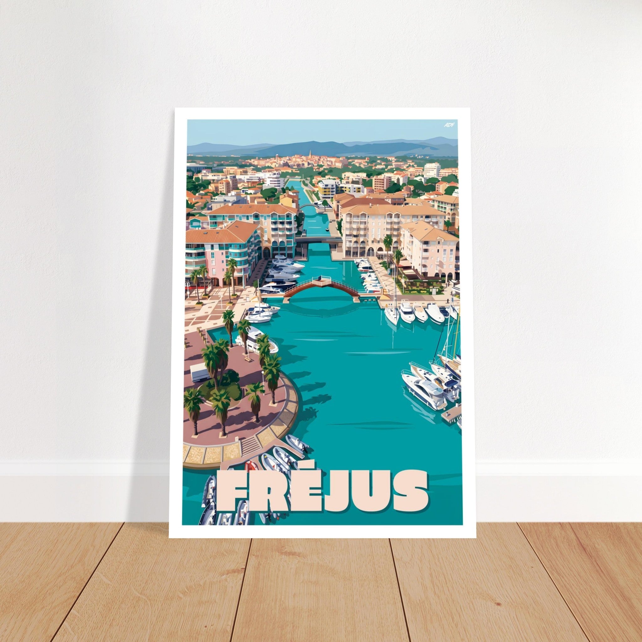 Grand tirage d'art sous cadre du poster de Fréjus posé sur du parquet contre un mur blanc
