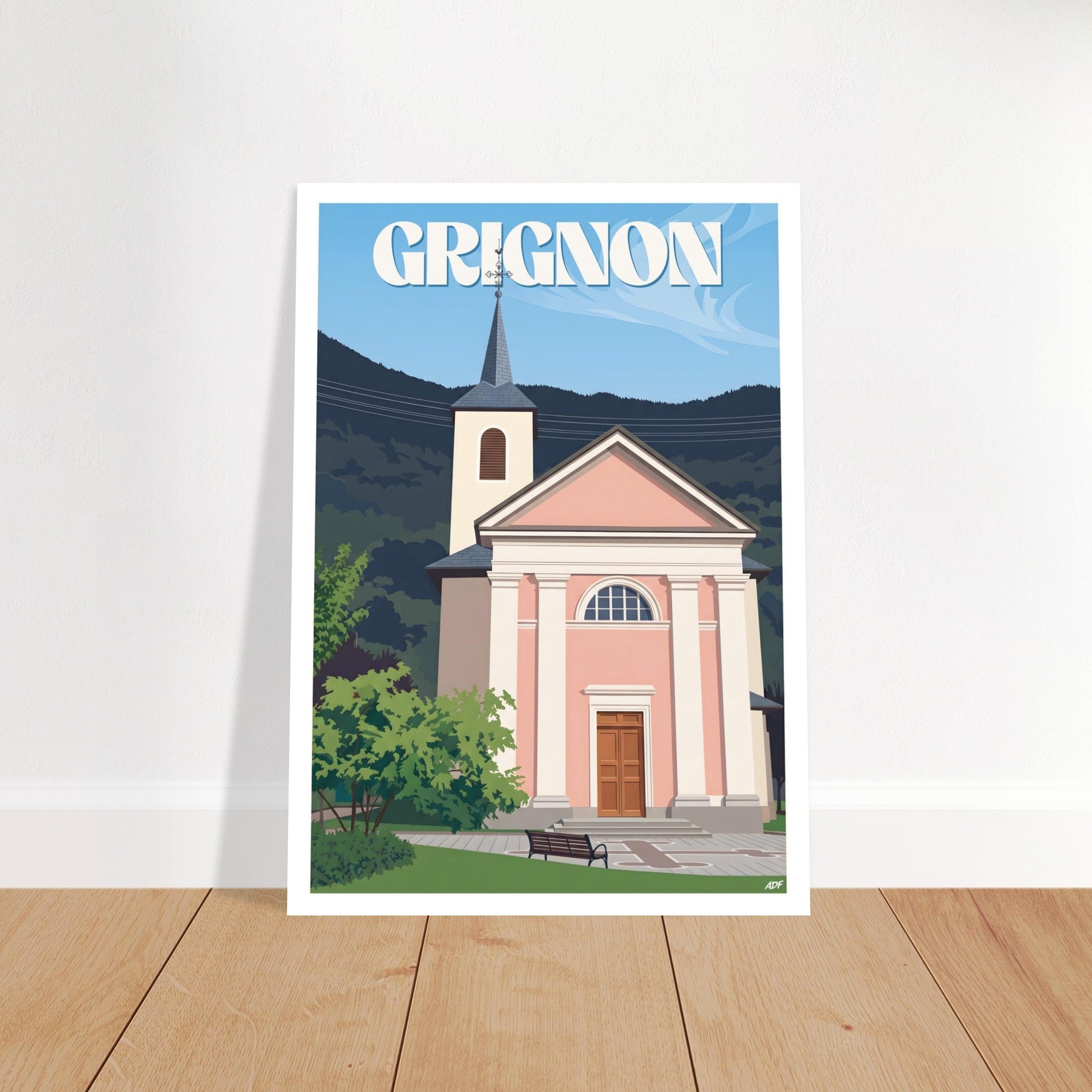 Grand poster encadré de Grignon posé sur parquet en bois contre un mur blanc