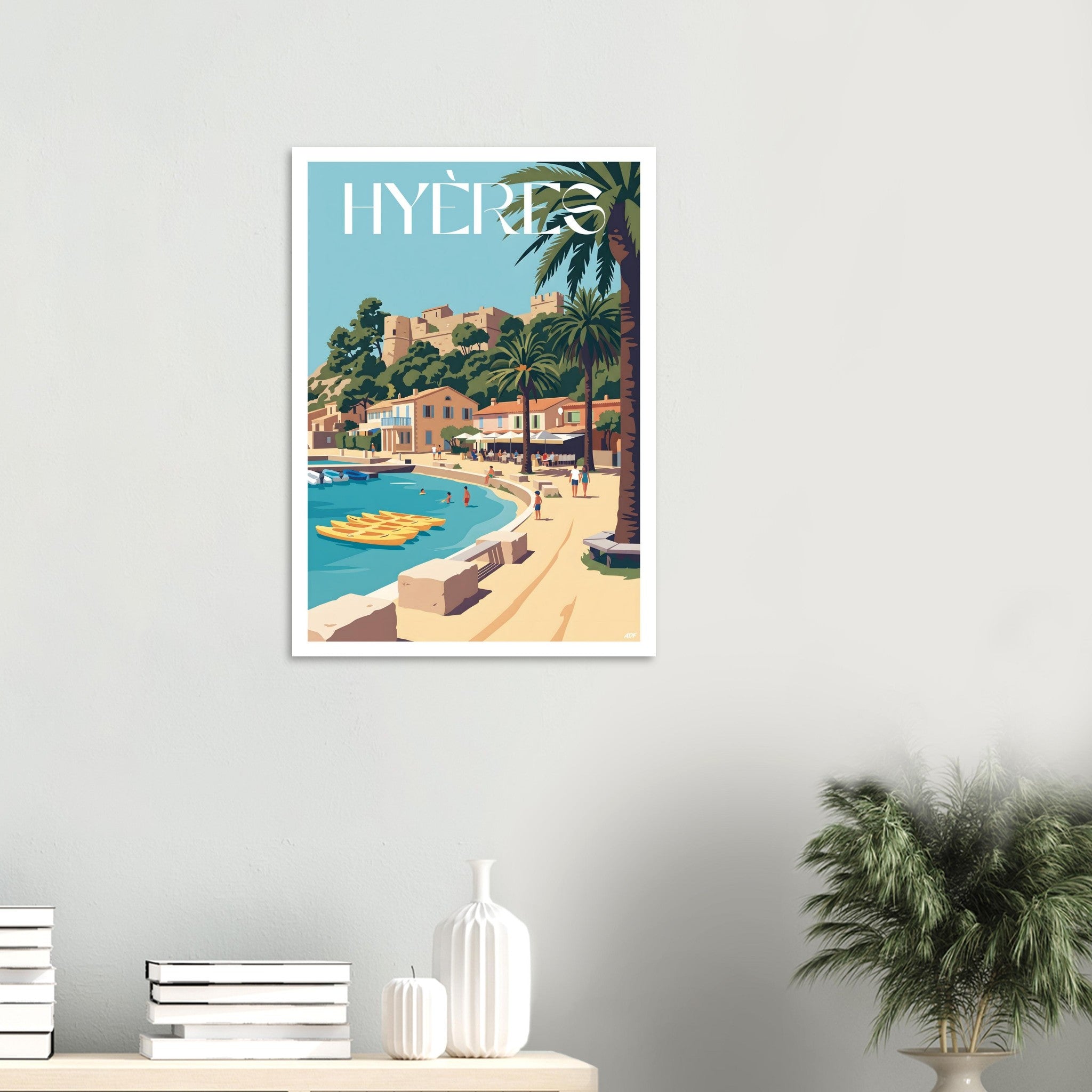 Affiche de voyage de Hyères posée sur un meuble en bois clair avec une plante verte