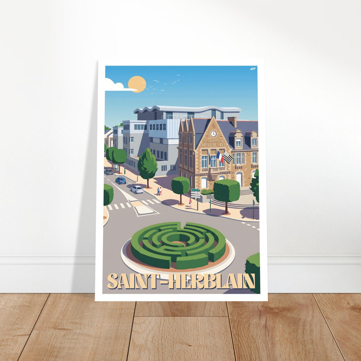 Grand poster encadré de l'hôtel de ville de Saint-Herblain posé sur parquet en bois contre un mur blanc