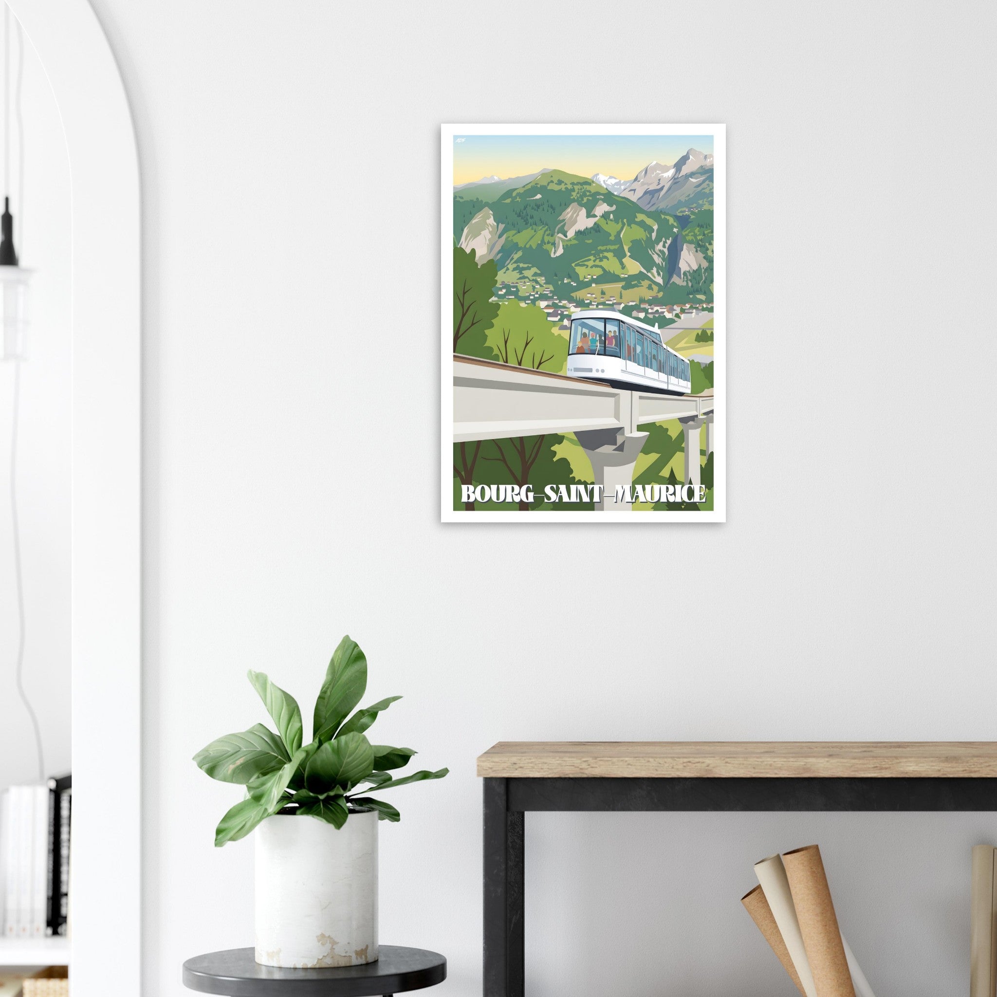 Poster de voyage alpin sous cadre posé sur une console avec déco végétale
