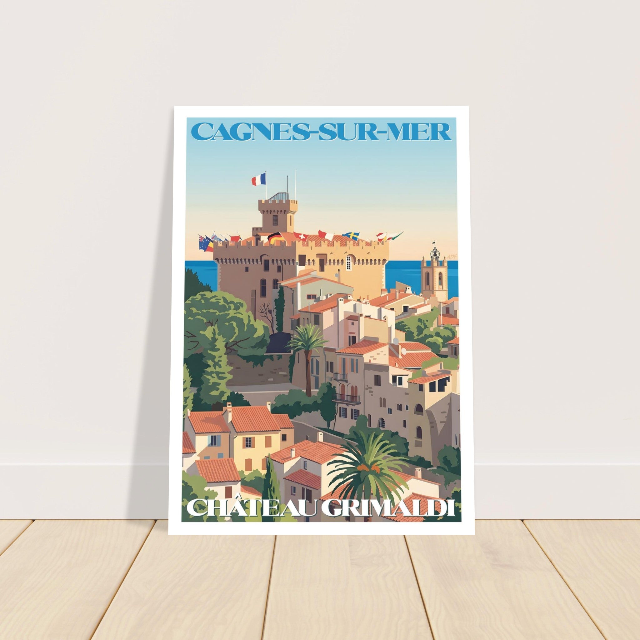 Affiche vintage de voyage de Cagnes-sur-Mer encadrée posée sur parquet en bois
