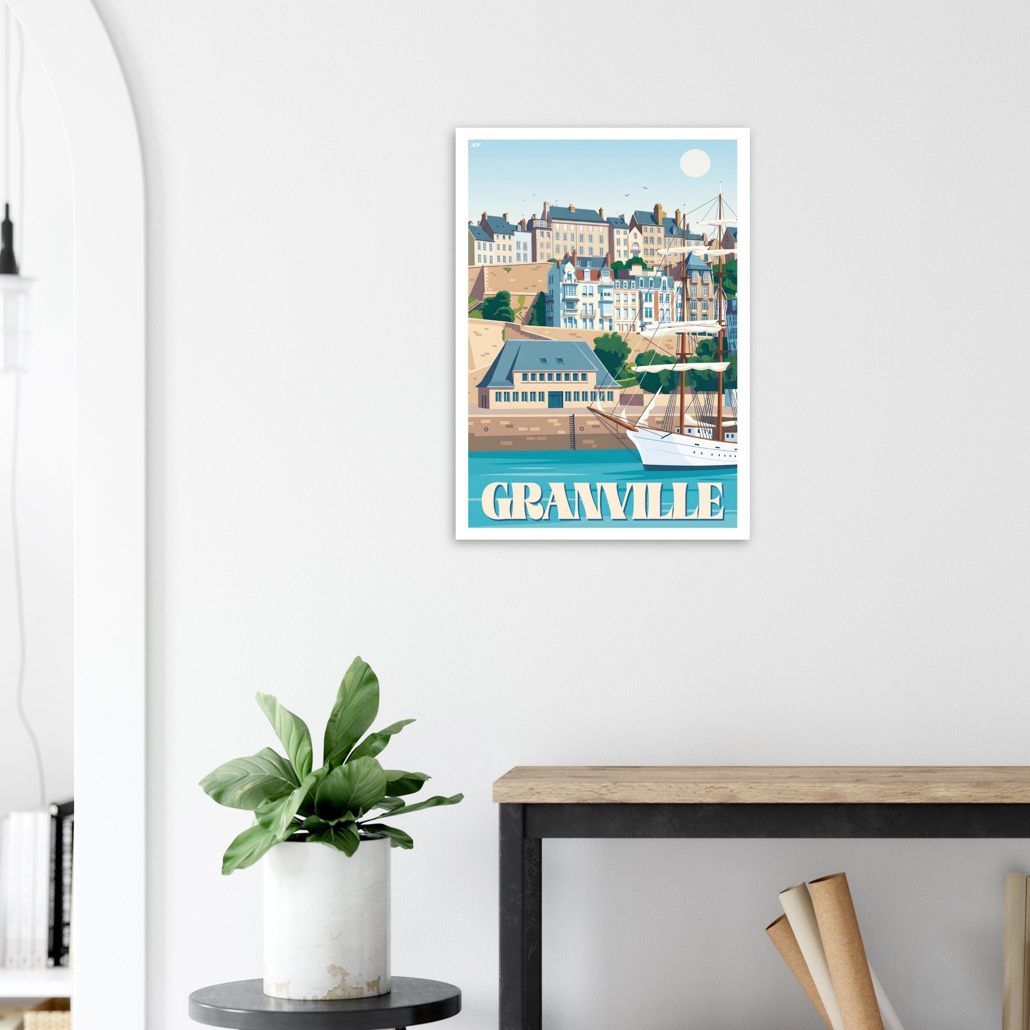 Affiche encadrée de Granville posée sur une console avec déco végétale