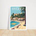 Grand cadre avec le poster de Hyères posé sur du parquet contre un mur clair